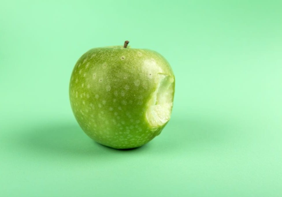 Apple with bite taken out of it.